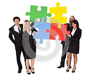 Group of business people assembling puzzle