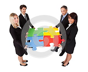 Group of business people assembling puzzle