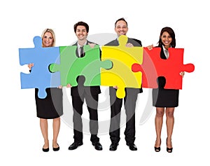 Group of business people assembling puzzle