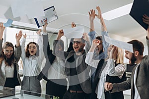 Group of business people celebrating by throwing their business papers and documents fly in air, Power of cooperation, Success