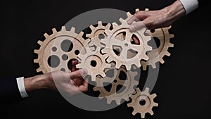 Group of business people connecting wooden cogwheels together. Office colleagues joining gears in chain.