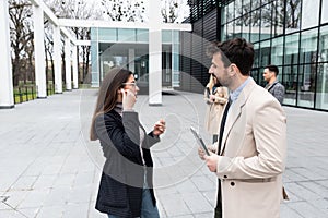 Group of business people discussing ideas at meeting outside. Businesswoman and businessman outdoor near office building talking