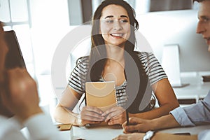 Group of business people discussing questions at meeting. Headshot of casual dressed businesswoman happy smiling to her