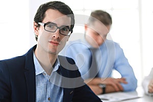 Group of business people discussing questions at meeting in modern office. Headshot of businessman at negotiation