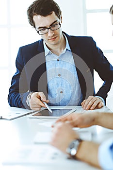 Group of business people discussing questions at meeting in modern office. Headshot of businessman at negotiation