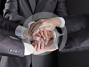Group of business people folded their hands together