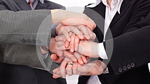 Group of business people with hands clasped together.