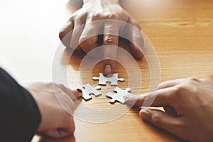 Group of Business people hands are holding jigsaw puzzle.