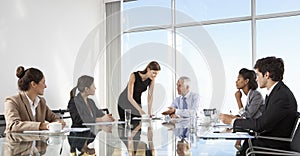 Group Of Business People Having Board Meeting Around Glass Table