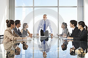 Group Of Business People Having Board Meeting Around Glass Table