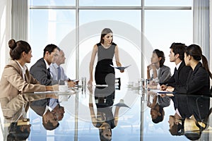 Group Of Business People Having Board Meeting Around Glass Table