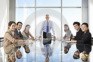 Group Of Business People Having Board Meeting Around Glass Table