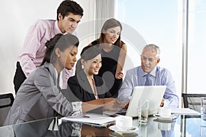 Group Of Business People Having Meeting Around Laptop At Glass T