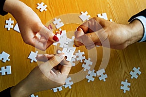 Group of business people help to assembling jigsaw puzzle