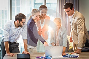 Group of business people interacting using laptop
