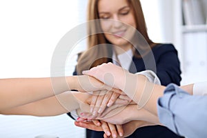 Group of business people joining hands, close-up. Teamwork, cooperation and success concept of communication