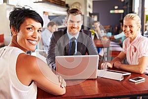 Group of business people with laptop meeting in coffee shop