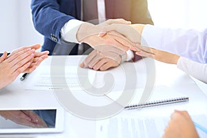 Group of business people or lawyers shaking hands finishing up a meeting , close-up. Success at negotiation and