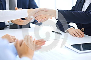 Group of business people or lawyers shaking hands finishing up a meeting , close-up. Success at negotiation and