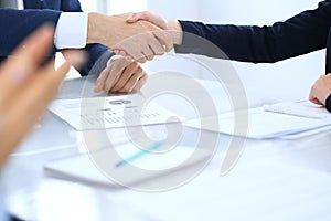 Group of business people or lawyers shaking hands finishing up a meeting , close-up. Success at negotiation and