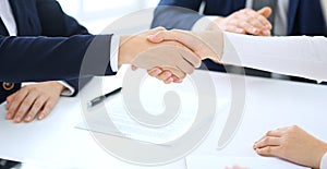 Group of business people or lawyers shaking hands finishing up a meeting , close-up. Success at negotiation and