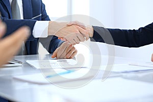 Group of business people or lawyers shaking hands finishing up a meeting , close-up. Success at negotiation and