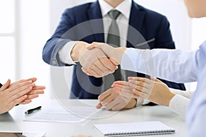 Group of business people or lawyers shaking hands finishing up a meeting , close-up. Success at negotiation and