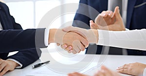 Group of business people or lawyers shaking hands finishing up a meeting , close-up. Success at negotiation and