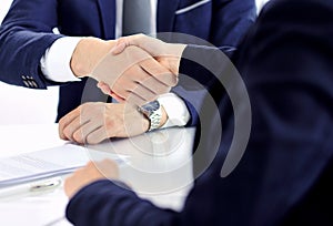 Group of business people or lawyers shaking hands finishing up a meeting , close-up. Success at negotiation and