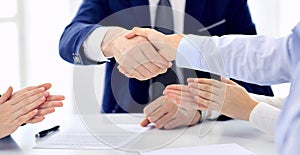 Group of business people or lawyers shaking hands finishing up a meeting , close-up. Success at negotiation and