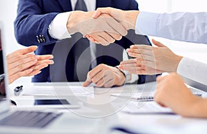 Group of business people or lawyers shaking hands finishing up a meeting , close-up. Success at negotiation and