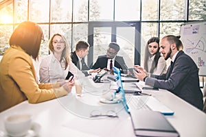 Group Of Business People Listening To Colleague Addressing Office Meeting