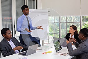 Group Of Business People Listening To Colleague Addressing Office Meeting