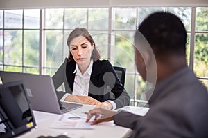 Group Of Business People Listening To Colleague Addressing Office Meeting