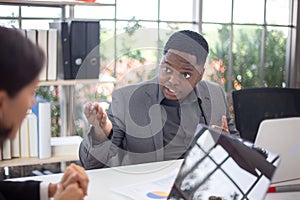 Group Of Business People Listening To Colleague Addressing Office Meeting