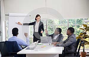 Group Of Business People Listening To Colleague Addressing Office Meeting