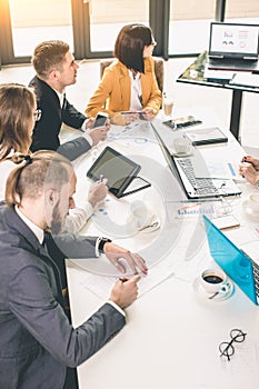 Group Of Business People Listening To Colleague Addressing Office Meeting