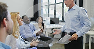 Group of business people listening to presentation ask question at seminar mature businessman leading training meeting