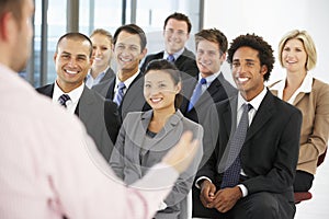 Group Of Business People Listening To Speaker Giving Presentation