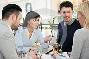 Group of business people meeting in coffee shop and holding a b