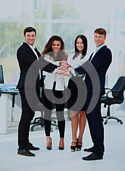 Group of business people piling up their hands together