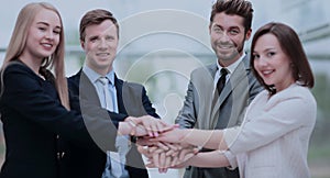 Group of business people putting their hands on top of each othe