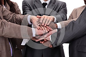 Group of business people putting their hands on top of each othe