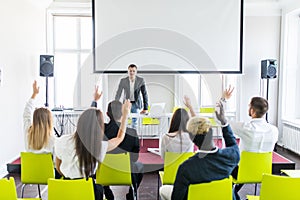 Group of business people raise hands up to agree with speaker in the meeting room seminar. Ask presenter
