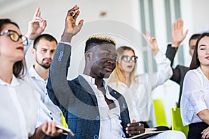 Group of business people raise hands up to agree with speaker in the meeting room seminar. Business concept