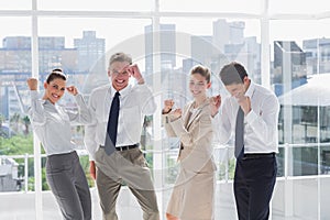 Group of business people raising arms as a success