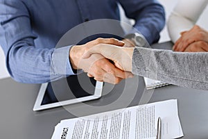 Group of business people shaking hands after discussing questions at meeting in modern office. Handshake close-up