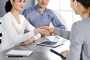 Group of business people shaking hands after discussing questions at meeting in modern office. Handshake close-up