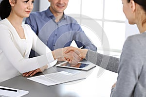 Group of business people shaking hands after discussing questions at meeting in modern office. Handshake close-up