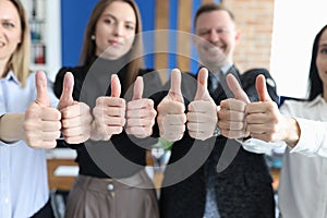 Group of business people showing thumb up in office closeup
